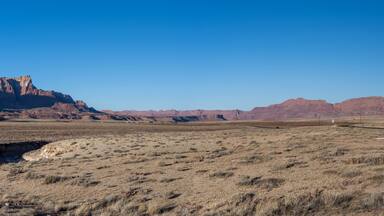 Der obere Teil bietet einen weiten, weiten Blick auf den Canyon und seine Umgebung bei strahlend blauem Himmel.