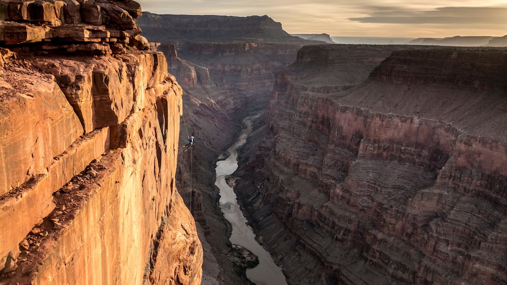 Un canyon aux formations rocheuses stratifiées, traversé par une rivière.