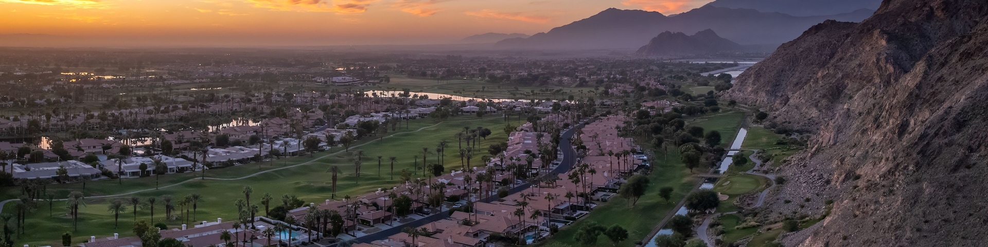 Zona residencial com casas, campo de golfe e rio.