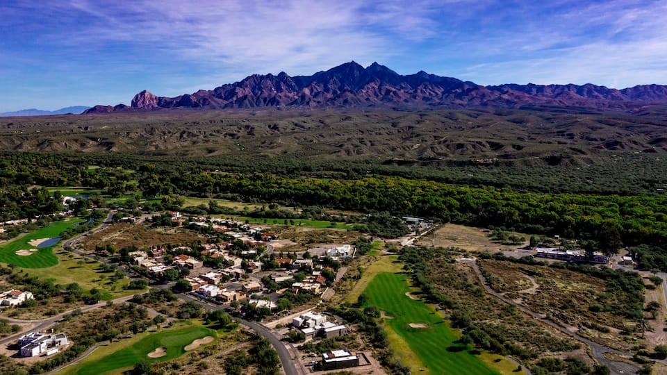 A town nestled in a valley with mountains in the background.