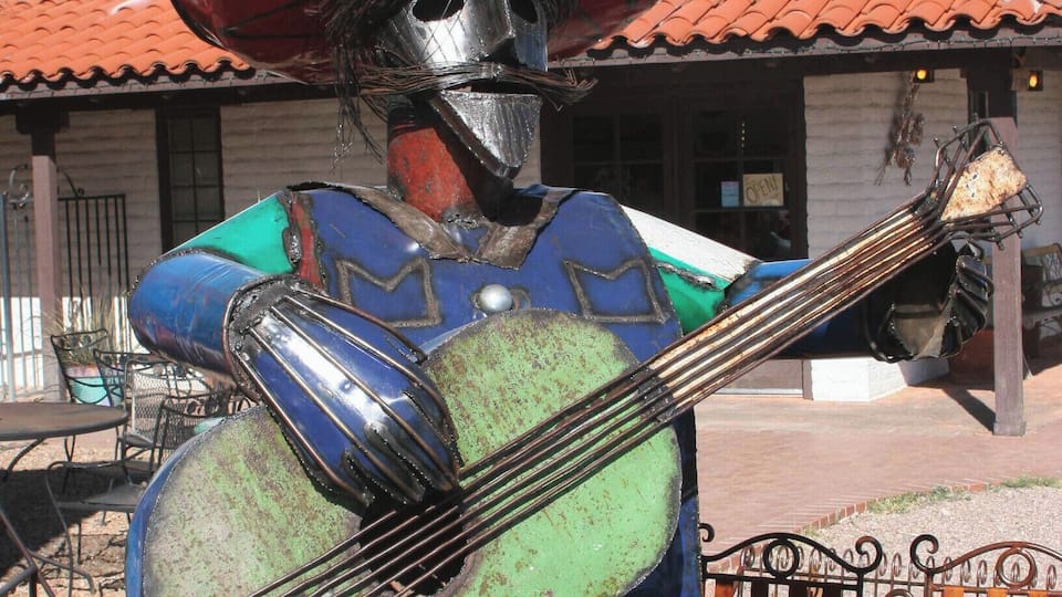 A colorful sculpture of a figure wearing a sombrero and playing a guitar.