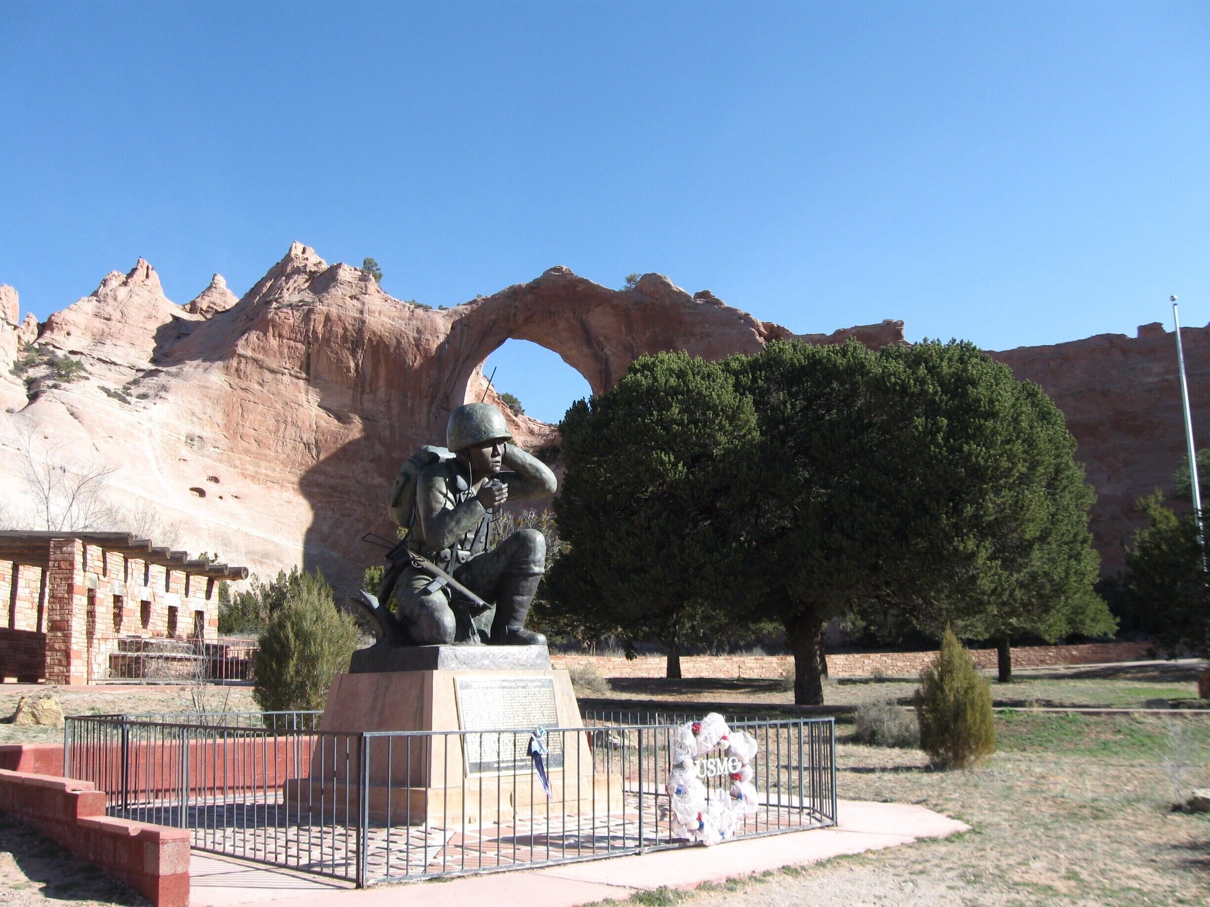 This memorial dedicated to the Navajo Code Talkers (Wind Talkers) is located within Window Rock Tribal Park. 
Speaking in their own language the Wind Talkers were responsible for the taking of Iwo Jima during World War II. Learn more at http://navajonationparks.org/htm/veterans.htm . Located about 20 miles North of Highway 40 within the Navajo Nation it is well worth a visit.