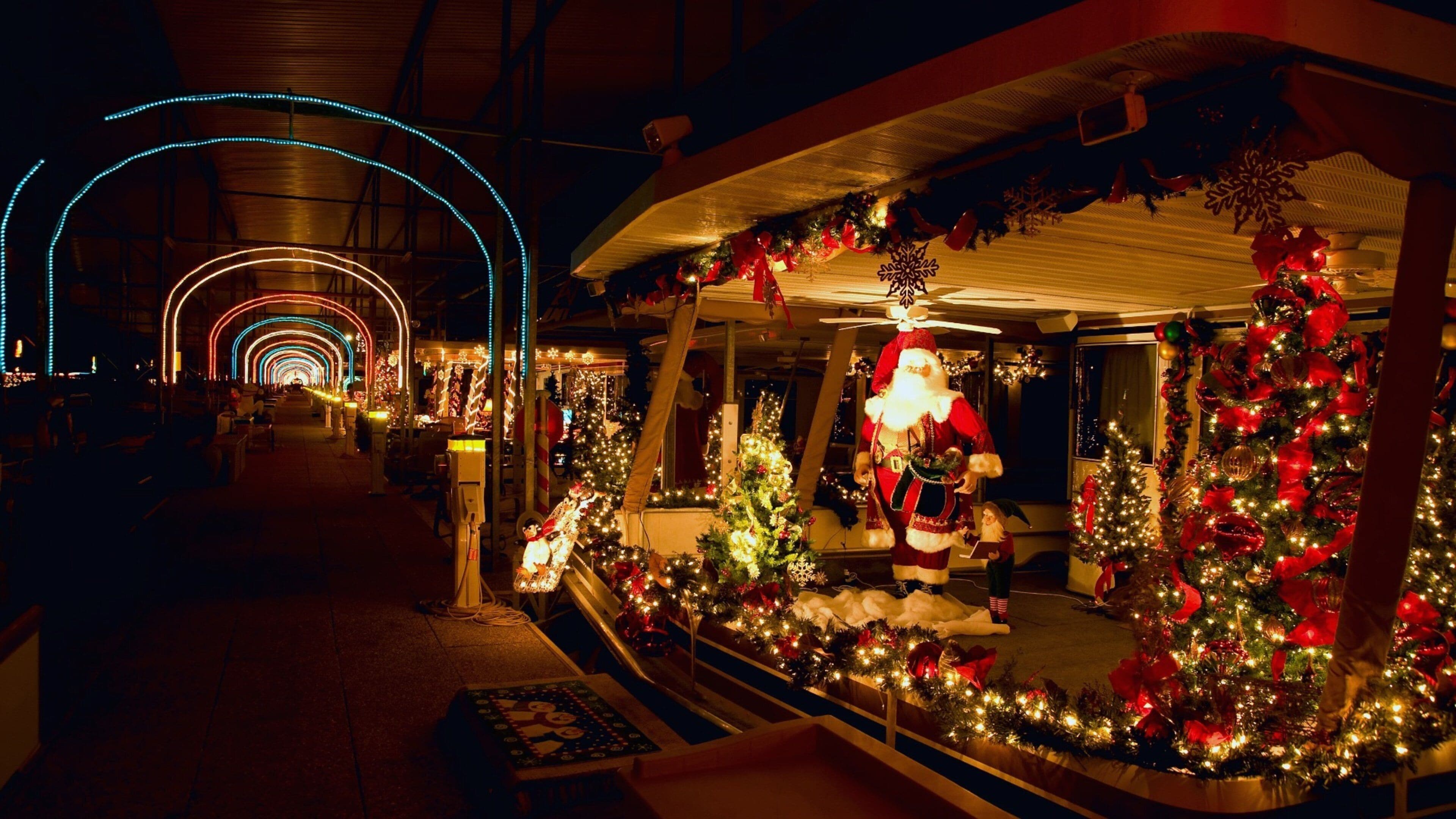 A festive indoor market with Christmas decorations, including a Santa Claus figure, Christmas trees, and illuminated arches.