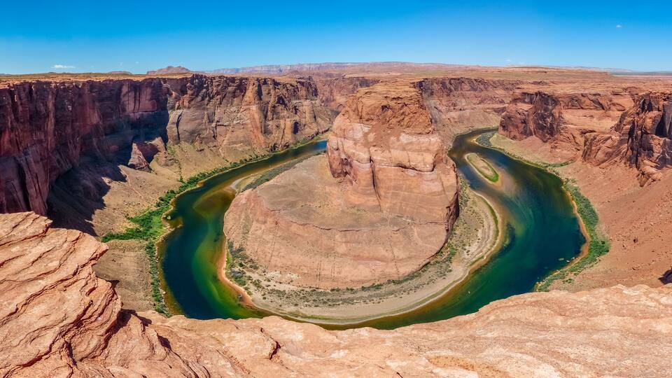 A deep canyon with a river winding through it.