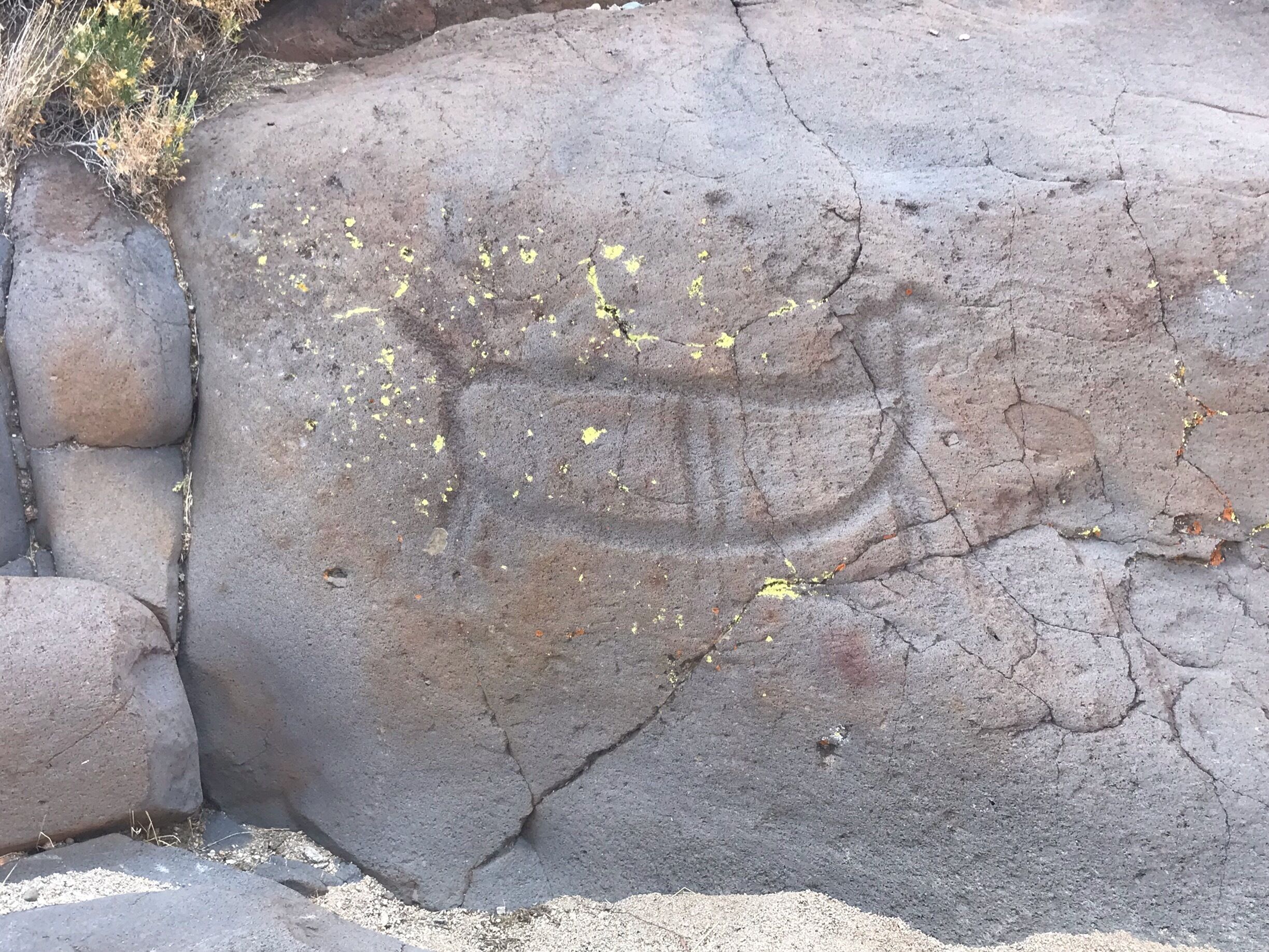 A large rock with yellow markings and cracks.