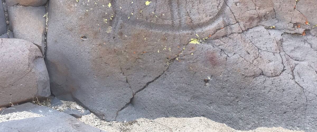 A large rock with yellow markings and cracks.
