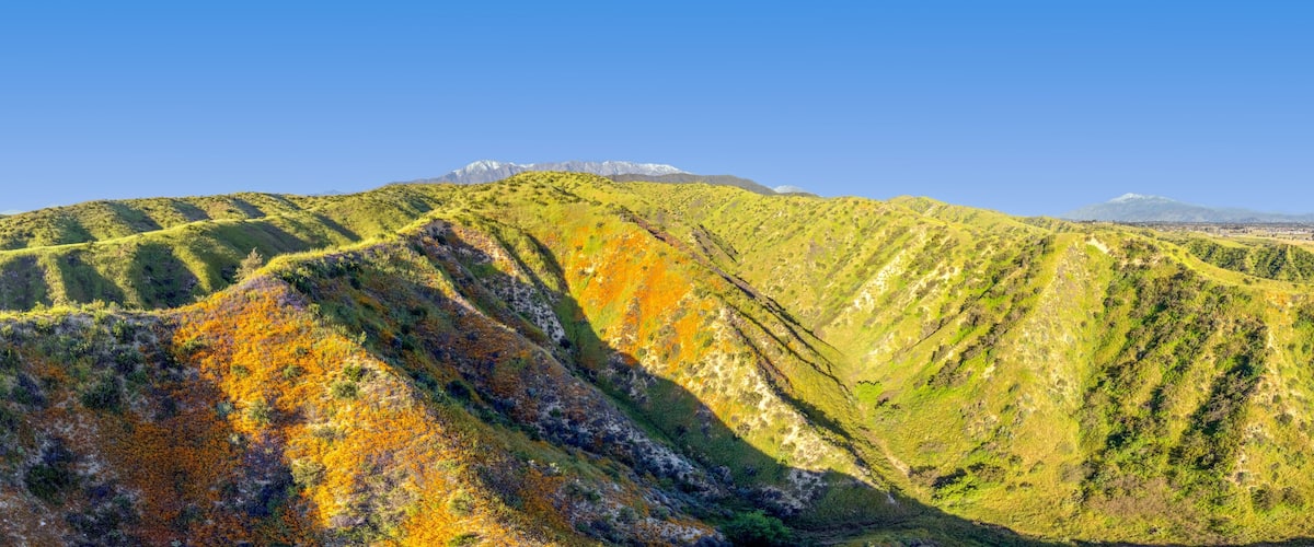 A mountain range with distinct ridges and a clear blue sky.