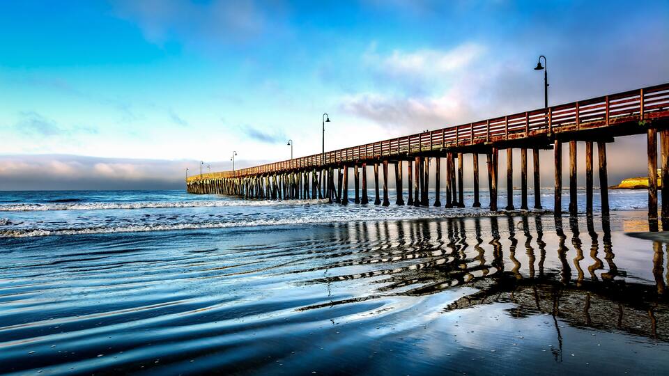 A pier extending into the water with a clear sky above.