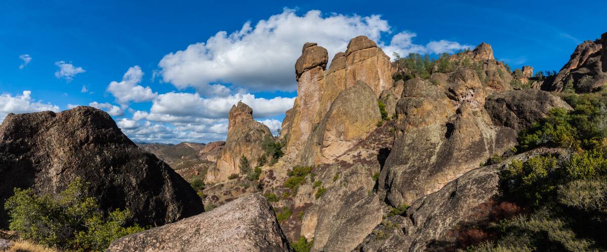 A rugged mountain landscape with prominent rock formations and sparse vegetation.