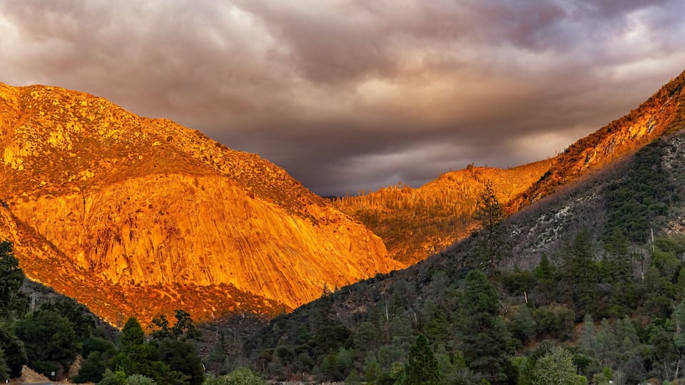 A mountain road with a rocky terrain and dense forest.