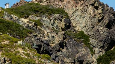 A rocky mountain with a lookout tower on top.