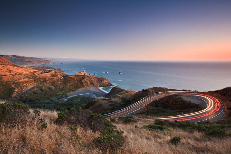 After sunset on the Pacific Ocean looking down the famous highway 1 as evening traffic travels in both directions