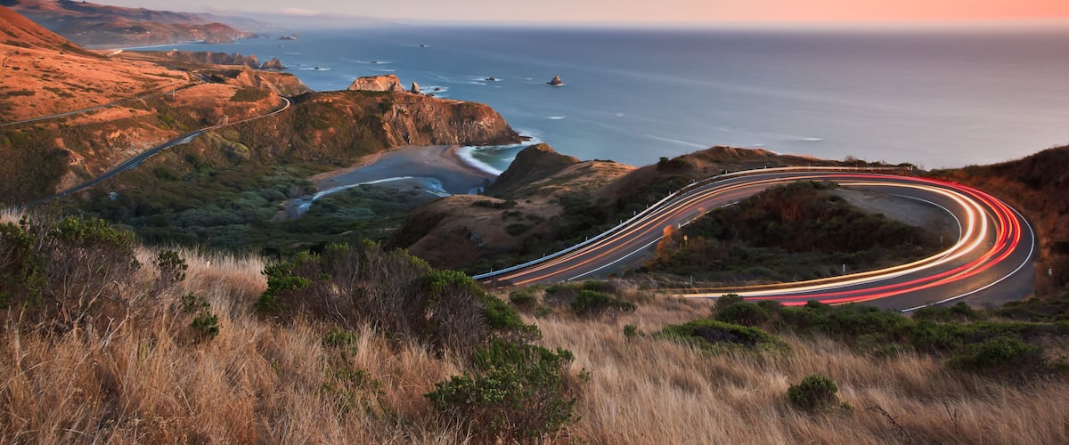After sunset on the Pacific Ocean looking down the famous highway 1 as evening traffic travels in both directions