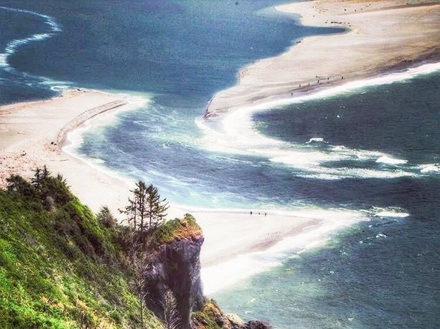Where fresh water meets the sea. The Klamath River flows into the Pacific in Redwoods State and National Park. The vista is stunning and there are people walking down by the water. #Adventure #redwoods #california #klamath #water #sea #pacific #ocean #landscape