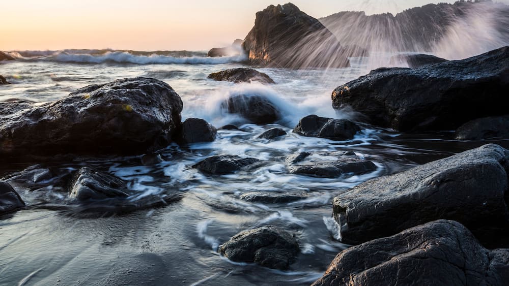A rocky shoreline with waves crashing against the rocks.
