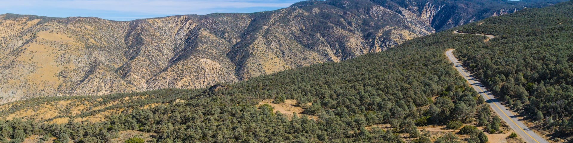 Highway runs across a mountain ridgeline in the California wilderness.