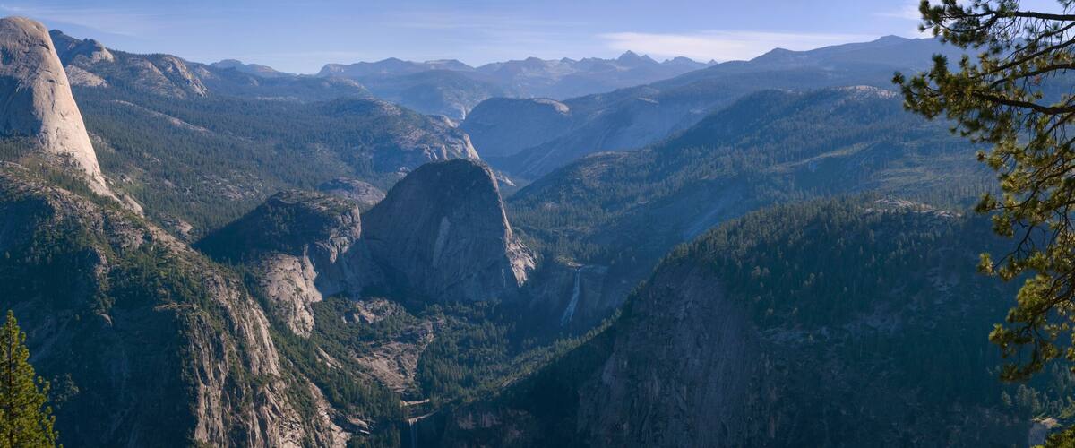 A mountainous landscape with prominent rock formations and dense forests.