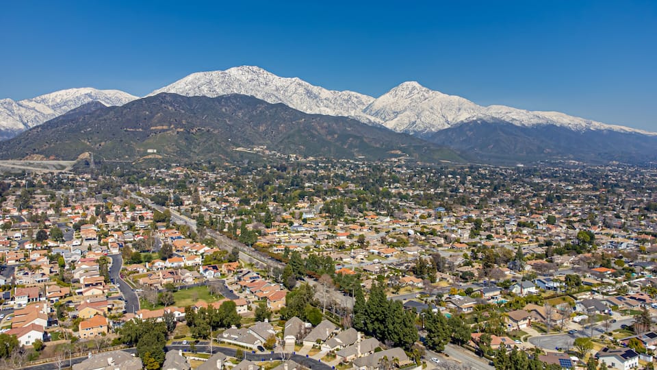 A town with snow-capped mountains in the background.