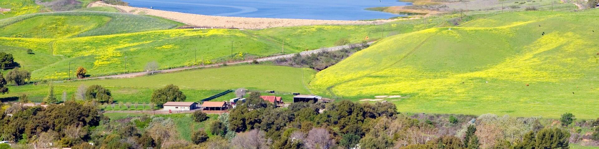 Elevated view of Lake Casitas and green fields in spring shot from Oak View, near Ojai, CA