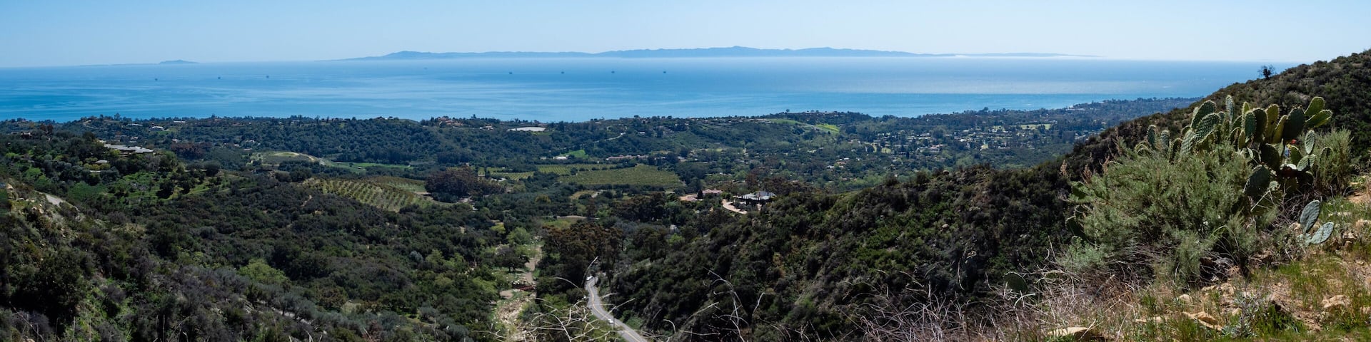 Panoramic view of Montecito, Pacific Ocean and Channel Islands from Old Romero Canyon Trail in Montecito, California near Santa Barbara on a clear, sunny spring day with prickly pear cactus