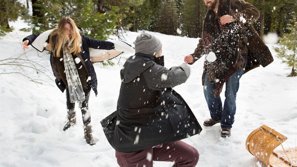 A snowy outdoor scene with people interacting.