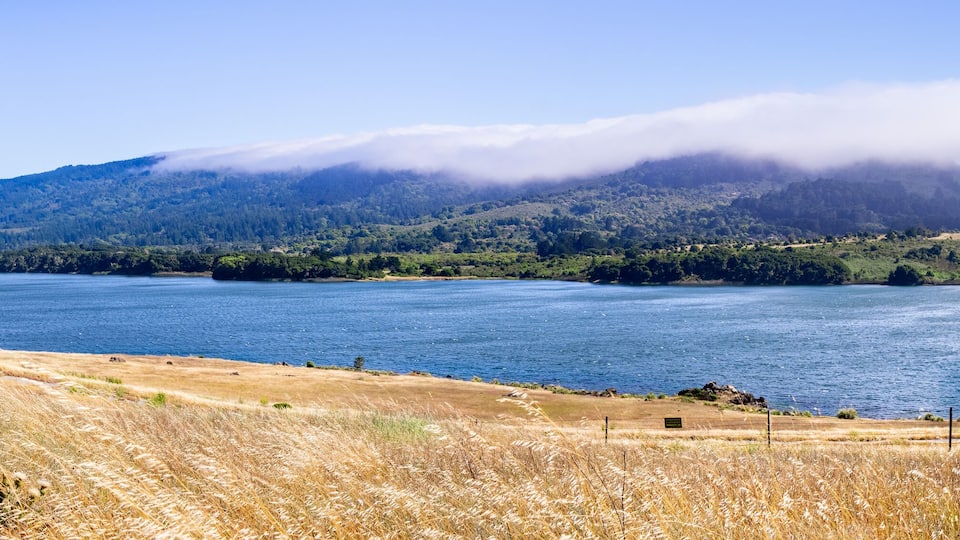 A lake surrounded by hills and dry grassland.