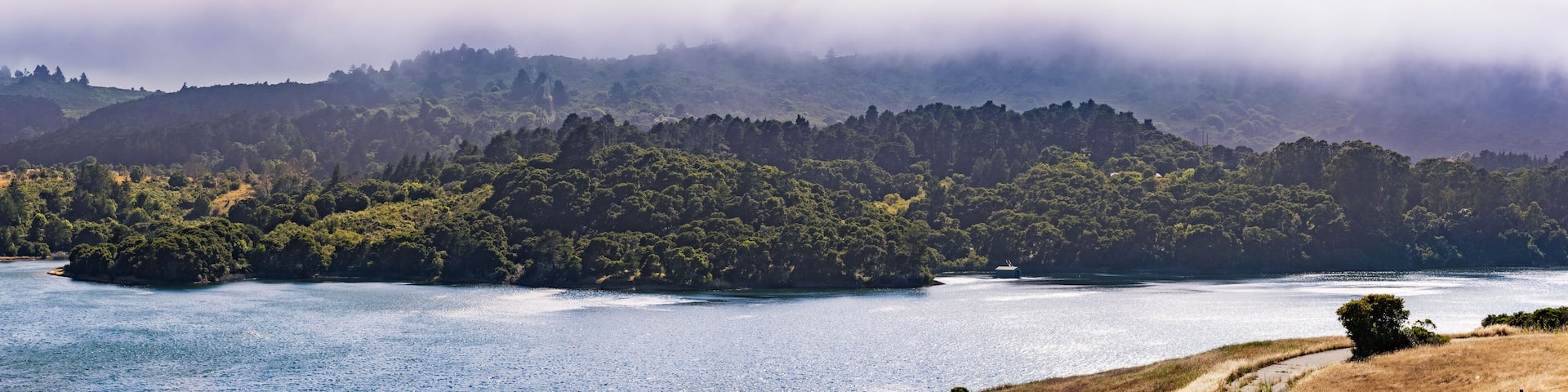Upper Crystal Springs Reservoir, part of the San Mateo Creek watershed and Santa Cruz mountains covered with clouds visible in the background; San Mateo, San Francisco bay area, California