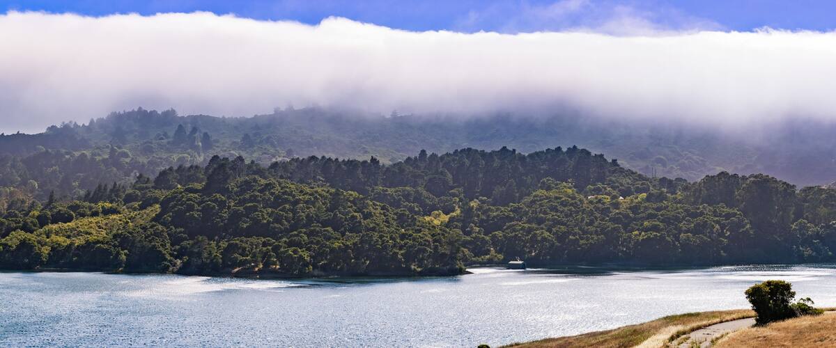 A lake surrounded by forested hills and a small island.
