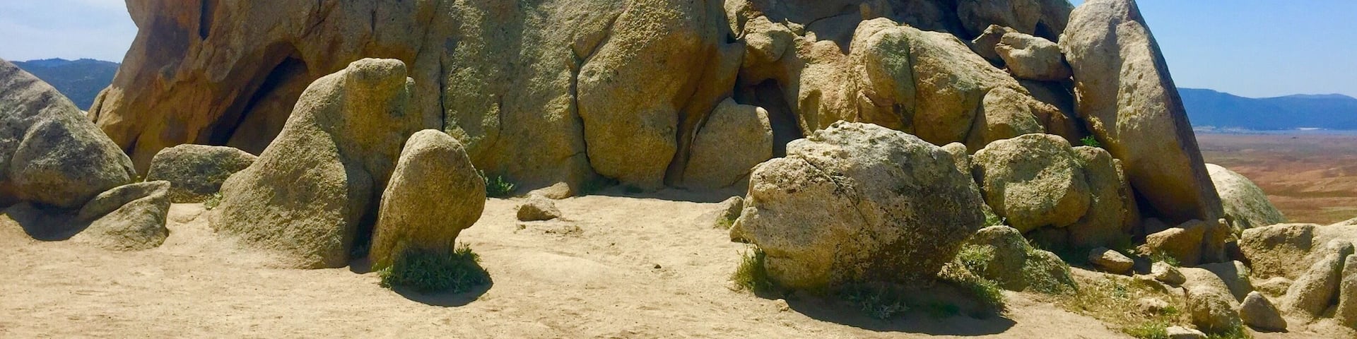 A rocky landscape with large boulders and a clear blue sky.