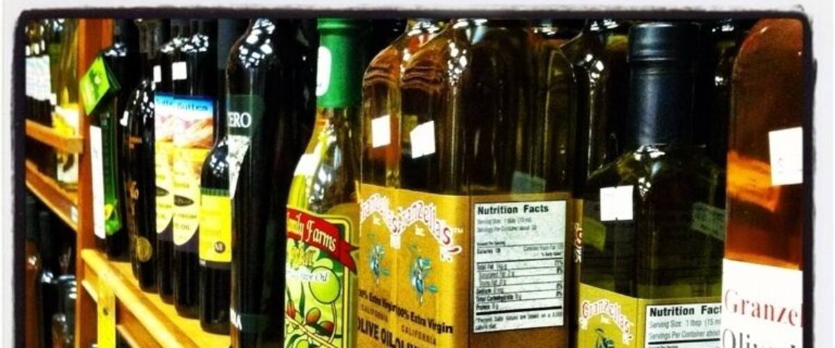 A shelf with various bottles of olive oil.