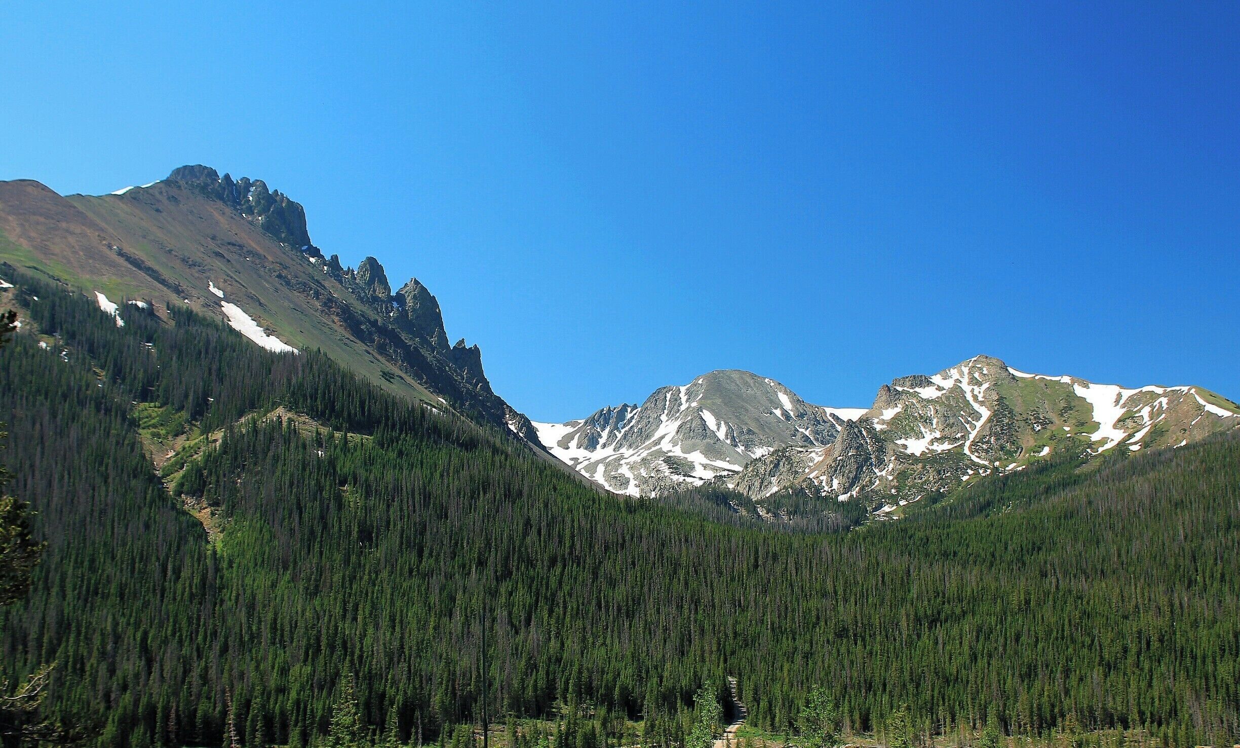 One of the many mountain views along the Cache la Poudre Scenic Byway. I'm not sure if these mountains are part of the Medicine Bow, Never Summer or Rabbit Ears mountain range but they are breathtakingly beautiful!
In the foreground is a dirt road that leads into State Forest State Park. Start the drive in Bellvue, Colorado and continue west towards Walden. Stop at all the pullouts and look for moose and big horn sheep, or picnic and fish the afternoon away. For some of the best moose watching in the state explore State Forest State Park. There are a multitude of camp grounds along the Byway. Explore the Arapaho National Wildlife Refuge and stay the night in Walden. Or, continue your drive south on Route 25 and stay in Grand Lake where you can shop, eat, hike, boat, fish... The possibilities are endless! #WeekendGetaway #CacheLaPoudreWilderness #ScenicByway #mountains #colorado #ArapahoNationalWildlifeRefuge #Wilderness #Walden #EndlessSummer #Colorful #Blue #Green