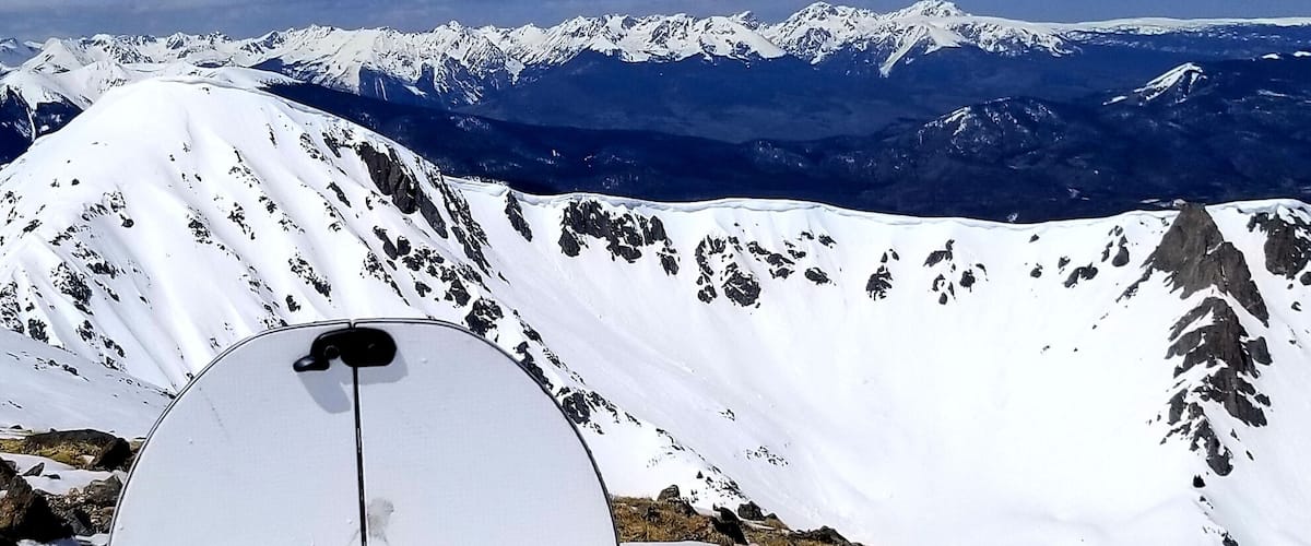 A snowboard with a mountain landscape in the background.