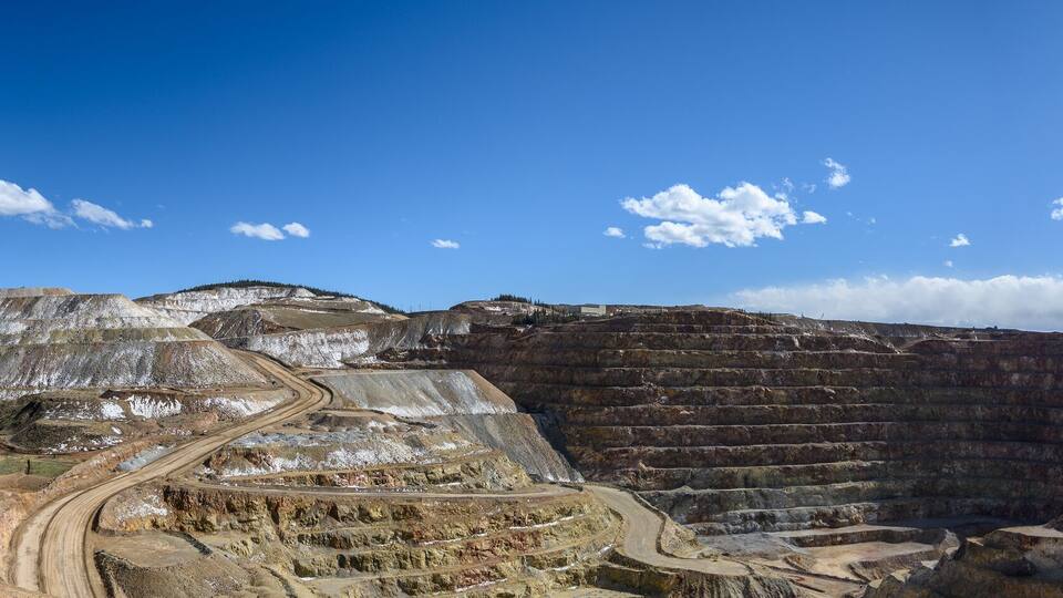 A large open-pit mine with terraced levels and winding roads.
