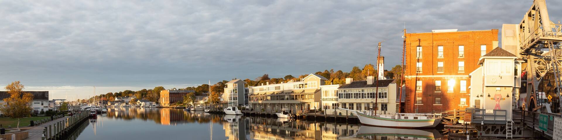 Mystic, Stonington, Connecticut, United States - October 26, 2018: Panoramic view of old historic homes by the Mystic River during a vibrant sunrise.
