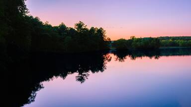 Sunset autumn landscape at Eagleville Pond and Preserve Dam over the Willimantic River in Coventry, Connecticut—a tranquil river scene in a quiet small New England town in America