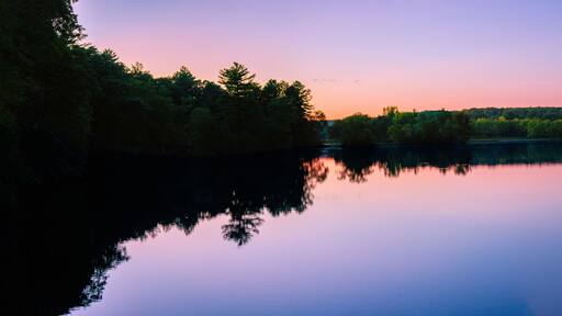 Sunset autumn landscape at Eagleville Pond and Preserve Dam over the Willimantic River in Coventry, Connecticut—a tranquil river scene in a quiet small New England town in America