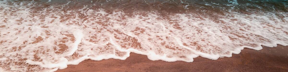 A beach with waves gently lapping onto the shore.