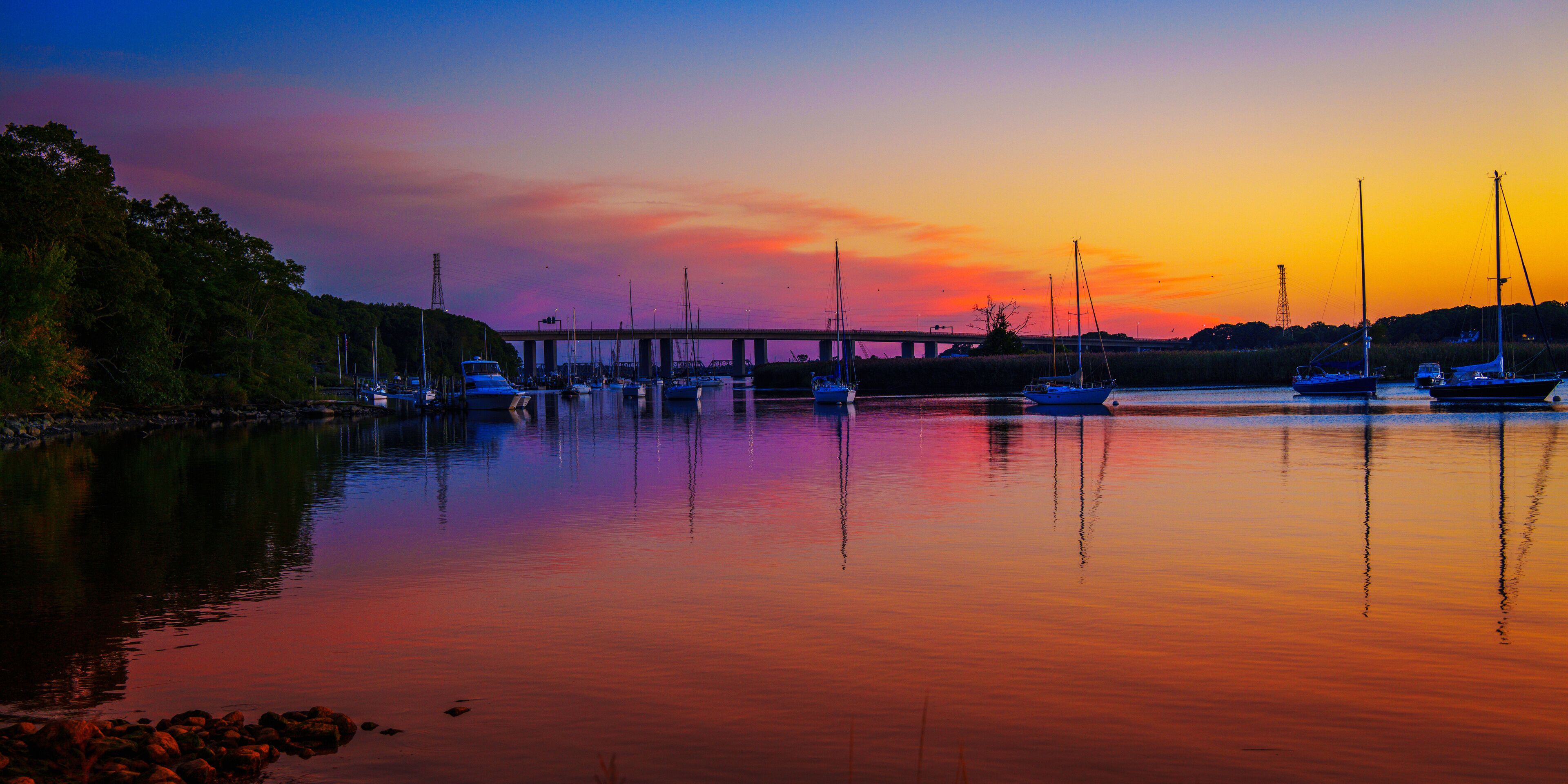 Seascape at sunset with moored boats and yachts at Old Lyme Marina in Connecticut, a vibrant autumn landscape of New England’s landmark marina
