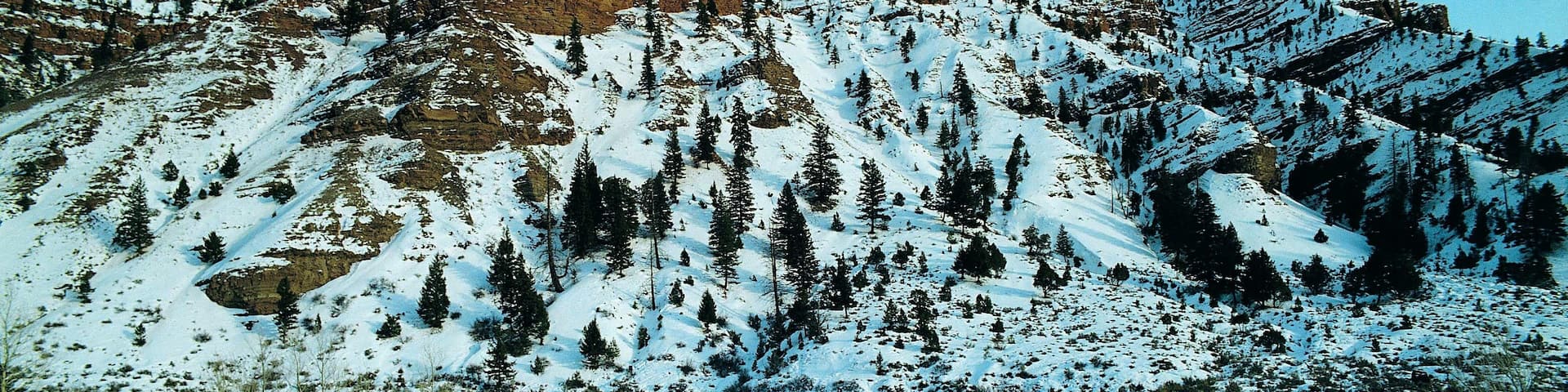 Red-brown rock strata showing through snow near Wolcott, Colorado, USA