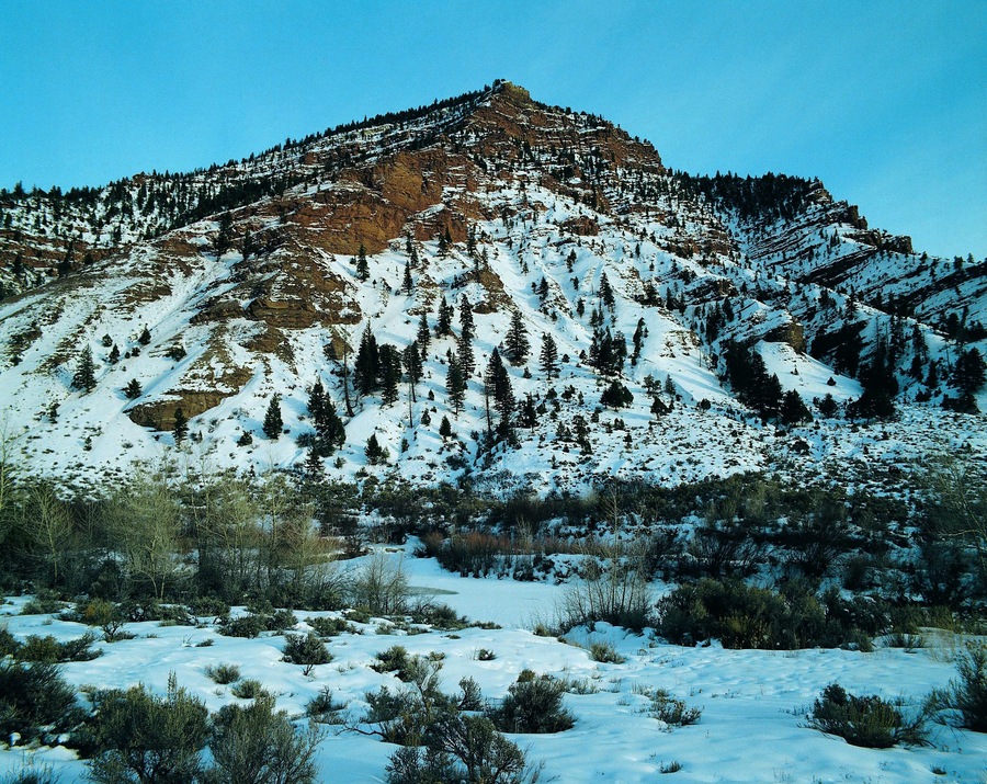 Red-brown rock strata showing through snow near Wolcott, Colorado, USA