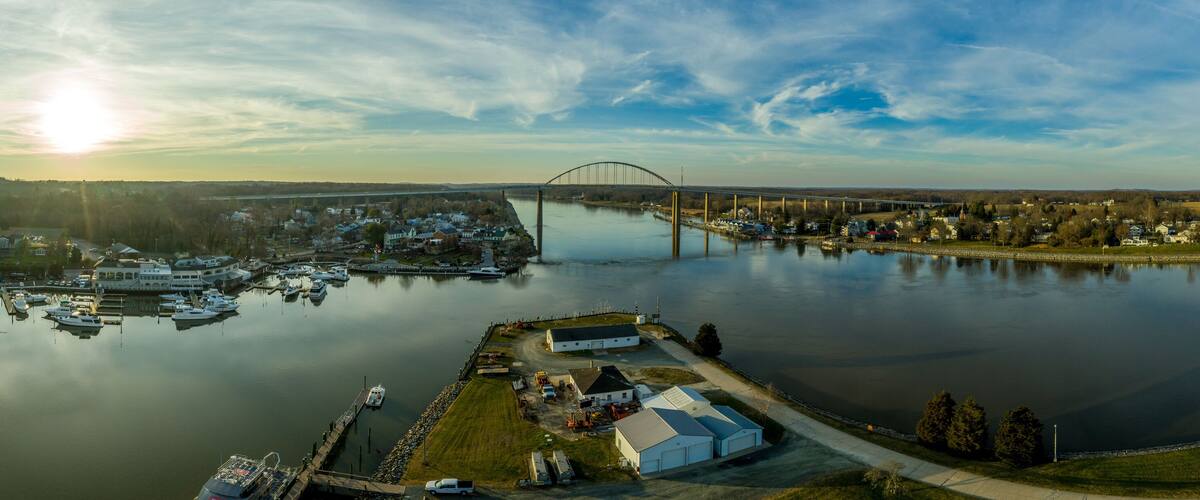 A river with a bridge, marina, and residential area.