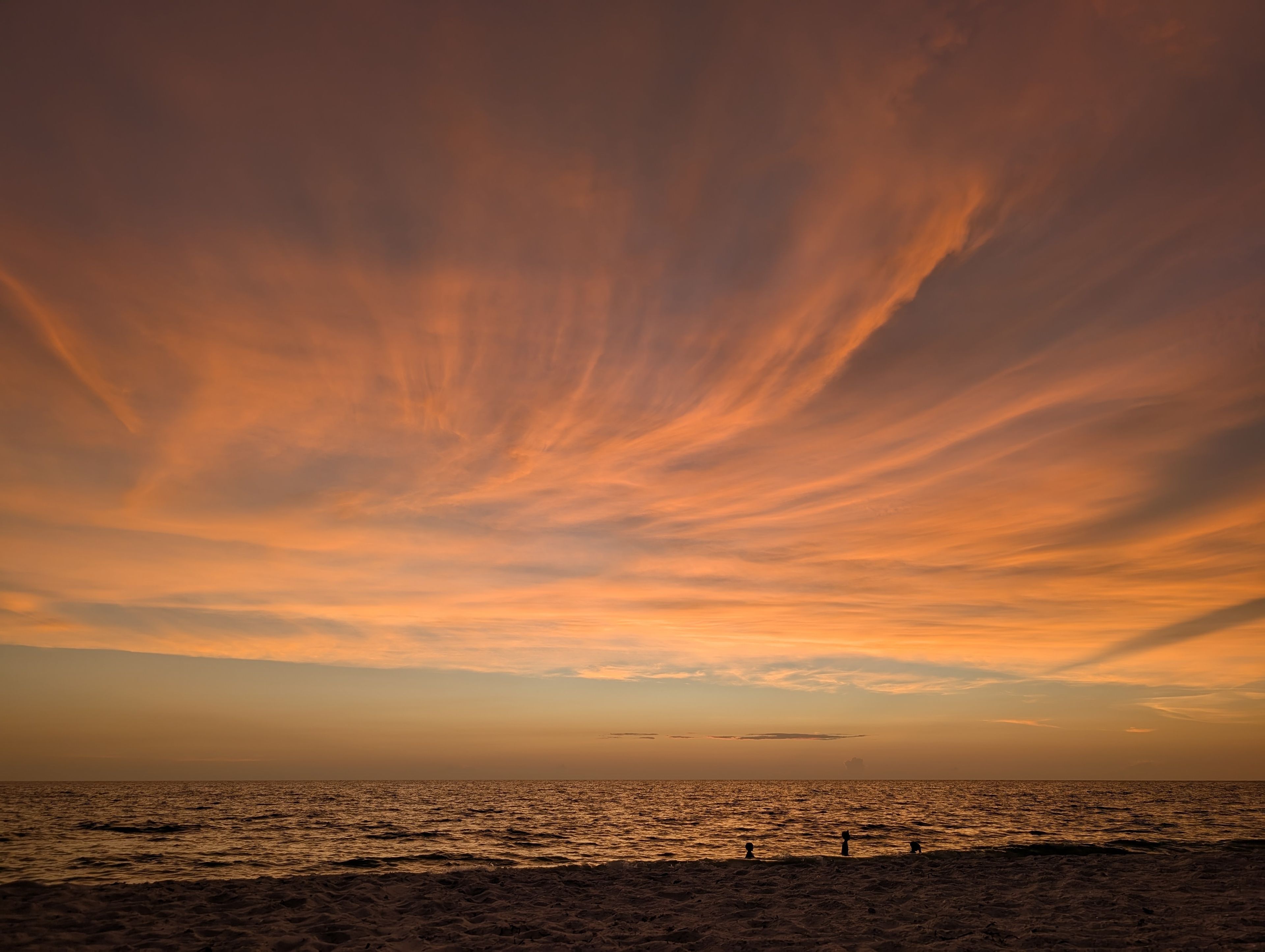 A beach with a sunset sky.