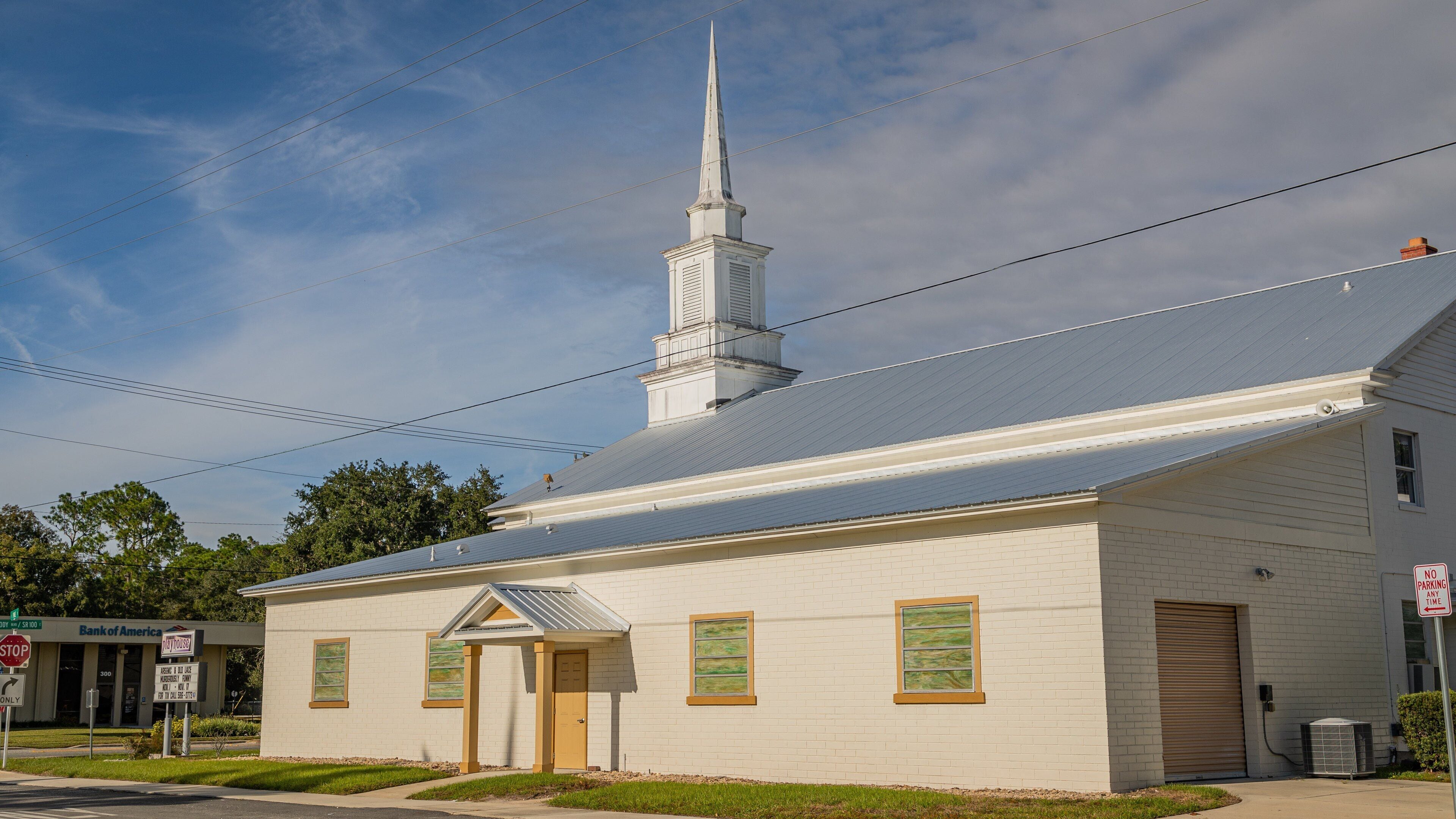 A white church with a steeple and a small bell tower.