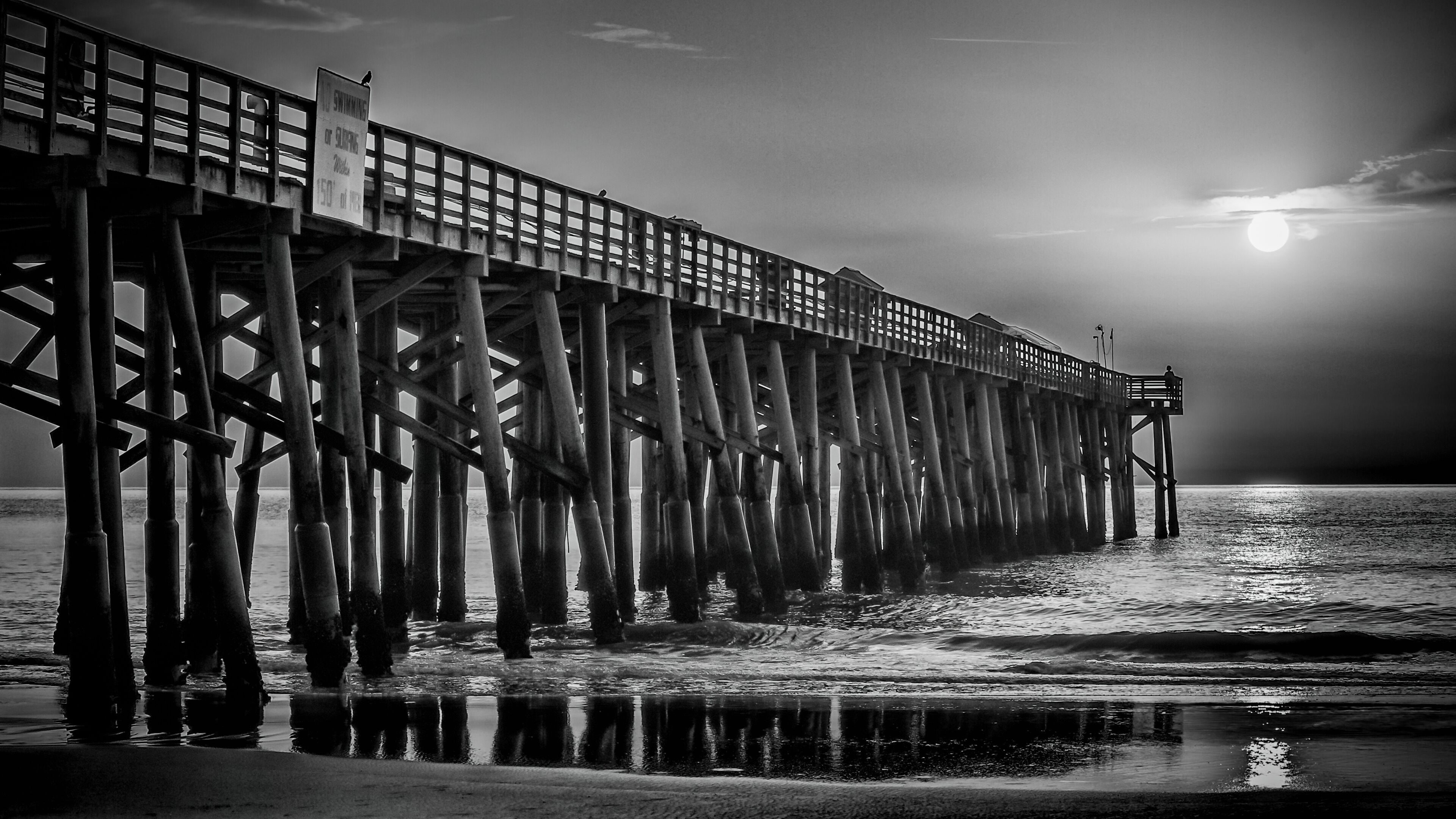 A pier extending into the water with a sign indicating no swimming.