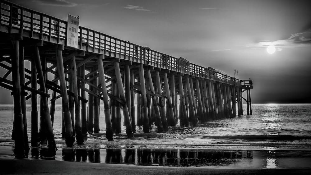 A pier extending into the water with a sign indicating no swimming.