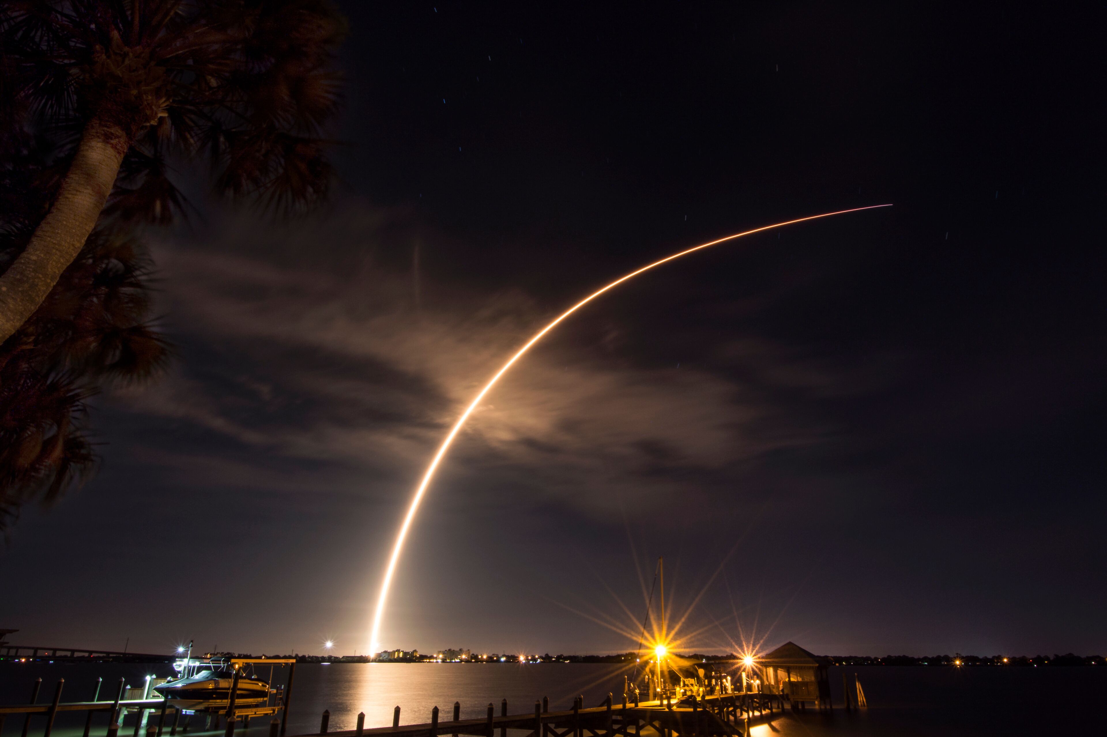 A rocket launches from Cape Canaveral,  carrying a communications satellite, over the Indian River Lagoon from Rockledge, Florida