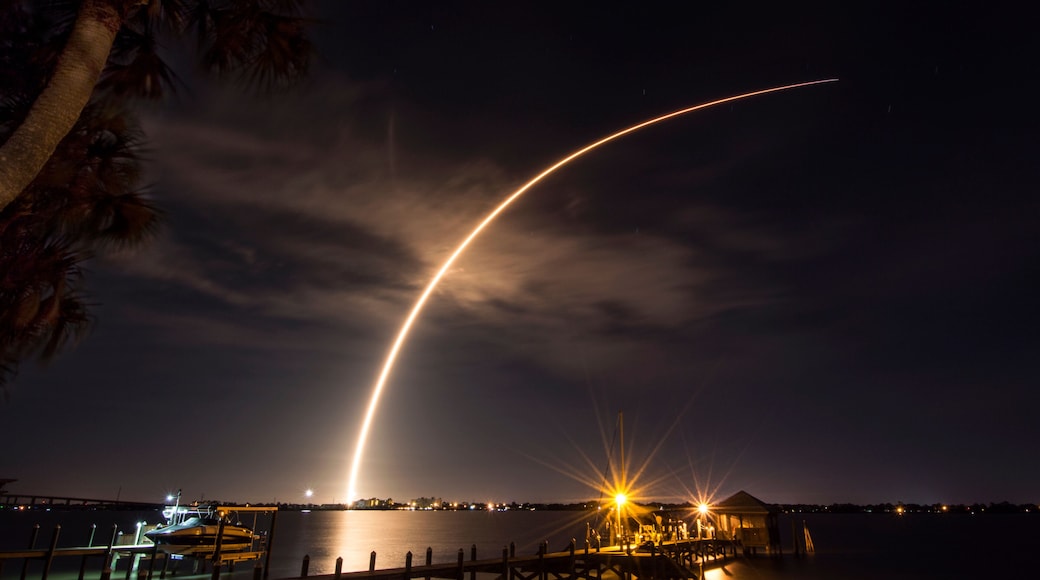 A rocket launches from Cape Canaveral, carrying a communications satellite, over the Indian River Lagoon from Rockledge, Florida