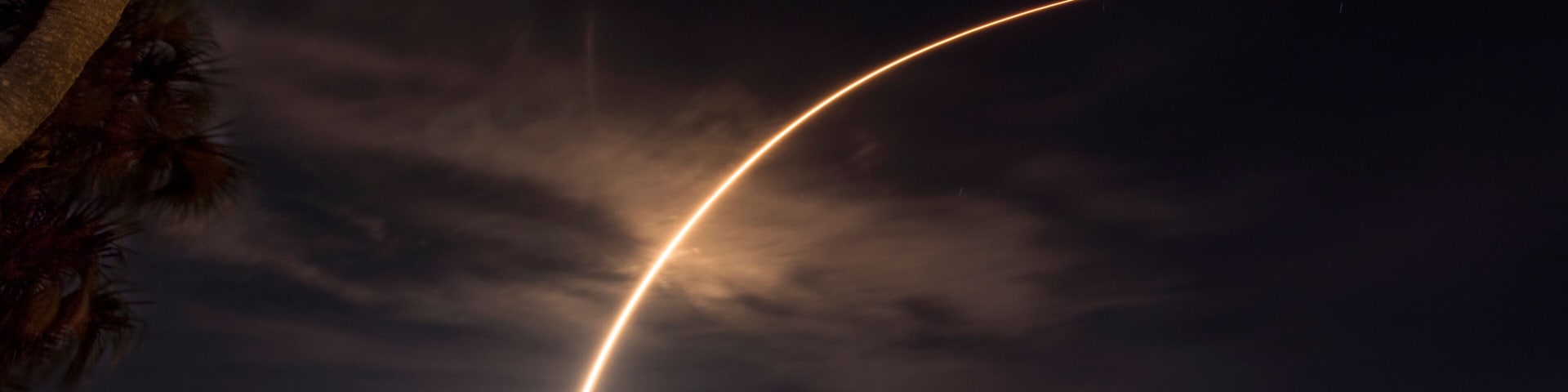 A rocket launches from Cape Canaveral, carrying a communications satellite, over the Indian River Lagoon from Rockledge, Florida