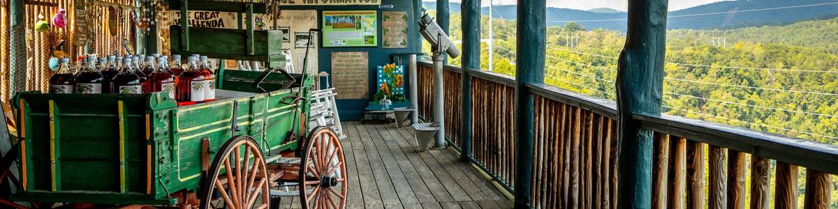 Une terrasse en bois avec un chariot vert et un télescope.