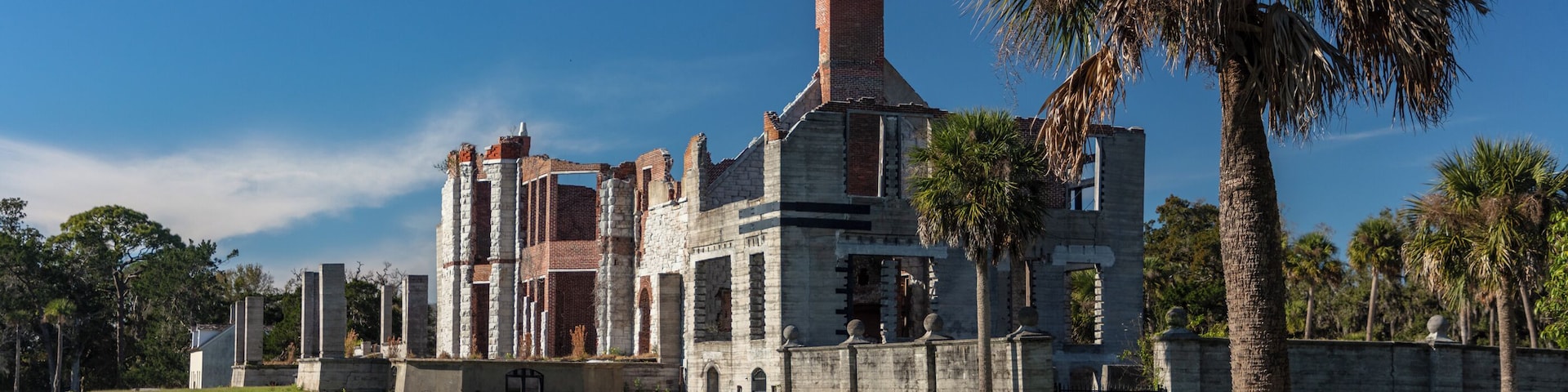 Dungeness on Cumberland Island, Georgia, is a ruined mansion that is part of a historic district that was the home of several families significant in American history. James Oglethorpe first built on Cumberland Island in 1736, building a hunting lodge that he named Dungeness. Oglethorpe named the place after Dungeness, in England. The next Dungeness was the legacy of Revolutionary War hero Nathanael Greene, who had acquired 11,000 acres of island land in exchange for a bad debt. His widow built a four-story tabby mansion in 1803, over a Timucuan shell mound. During the War of 1812 the island was occupied by the British, who used the house as a headquarters.
In 1818 Henry “Light-Horse Harry” Lee, a dashing cavalry commander during the Revolutionary War and father of Robert E. Lee, stayed at the house until his death on March 25, 1818, cared for by Greene's daughter Louisa, and was laid to rest in nearby cemetery with full military honors provided by an American fleet stationed at St. Marys, Georgia. The house was abandoned during the U.S. Civil War and burned in 1866.
In the 1880s the property was purchased by Thomas M. Carnegie, brother of Andrew Carnegie, who began to build a new mansion on the site. The 59-room Queen Anne style mansion and grounds were completed after Carnegie's death in 1886. His wife Lucy continued to live at Dungeness and built other estates for her children, including Greyfield for Margaret Carnegie, Plum Orchard for George Lauder Carnegie, and Stafford Plantation. By this time, the Carnegies owned 90% of the island.
The Carnegies moved out of Dungeness in 1925. In 1959 the Dungeness mansion was destroyed by fire, alleged to be arson. The ruins are today preserved by the National Park Service as part of Cumberland Island National Seashore. They were acquired by the Park Service in 1972.